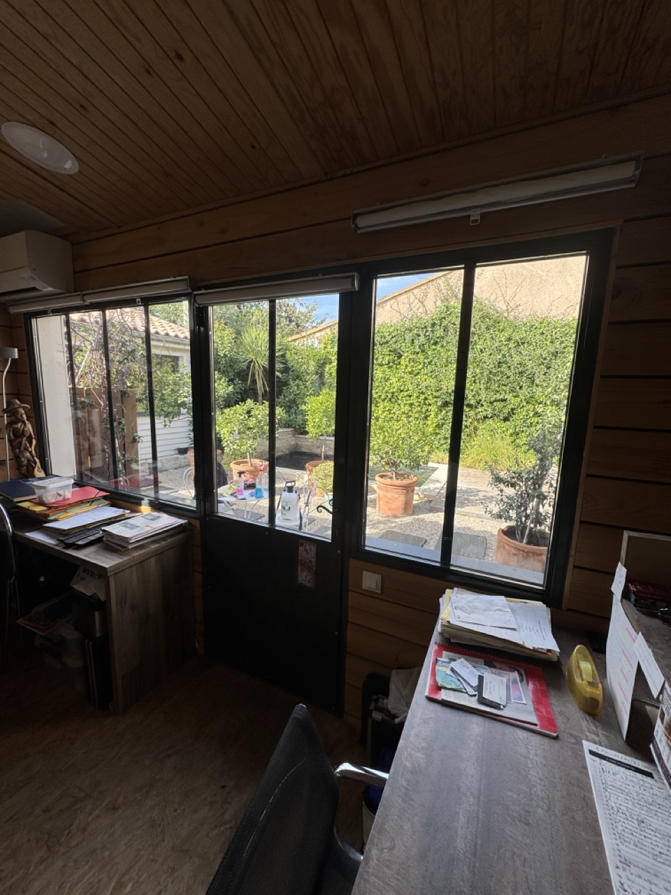 Bureau climatisé avec dossiers et plans de travail devant les vitrages plein sud équipés du film solaire